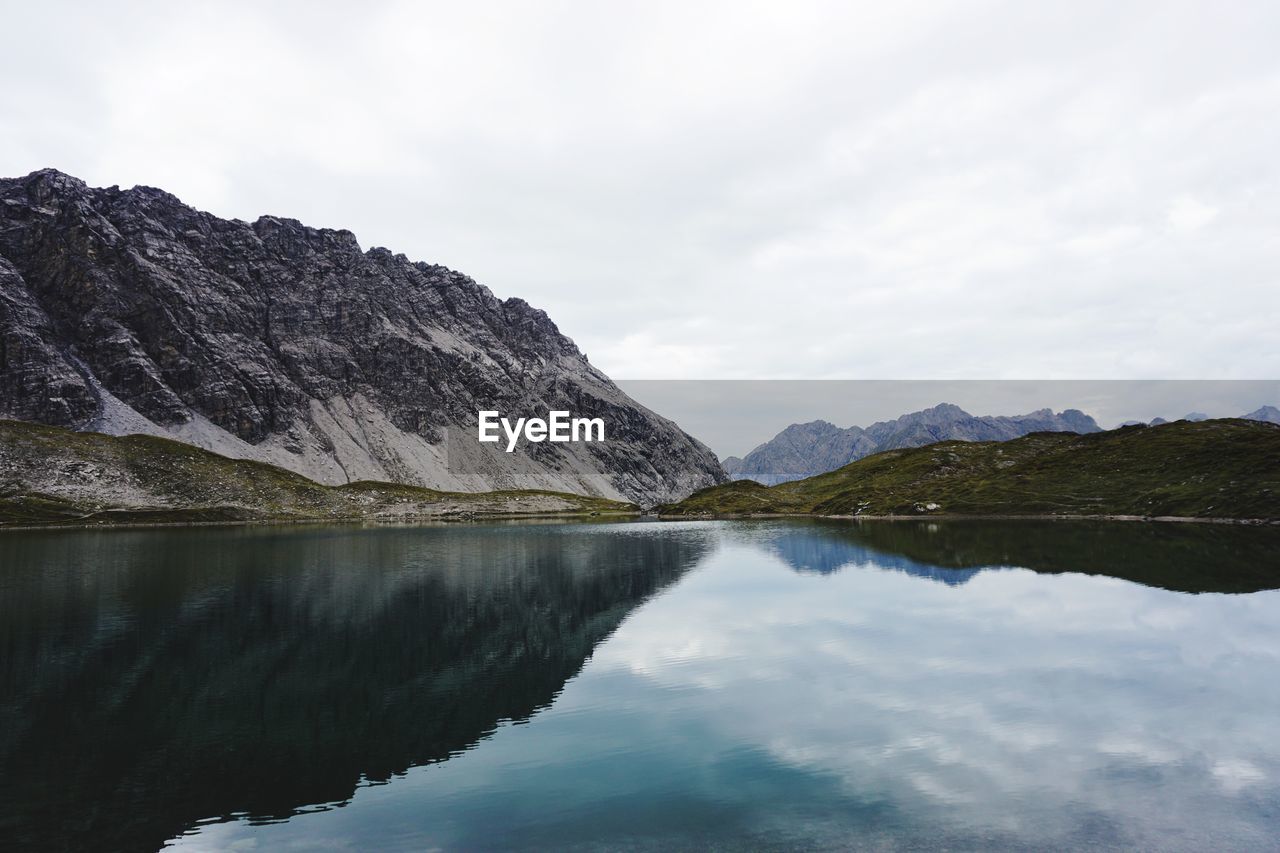 Scenic view of lake by mountains against sky