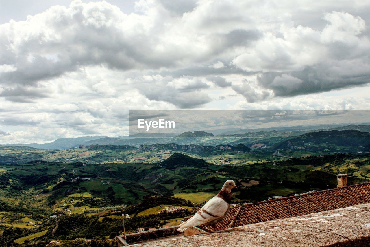 SCENIC VIEW OF MOUNTAINS AGAINST CLOUDY SKY