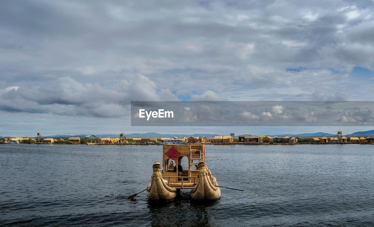 FERRY BOAT IN RIVER AGAINST SKY