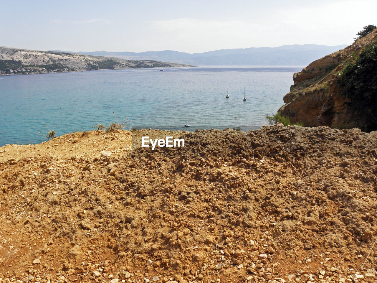 SCENIC VIEW OF SEA BY MOUNTAIN AGAINST SKY