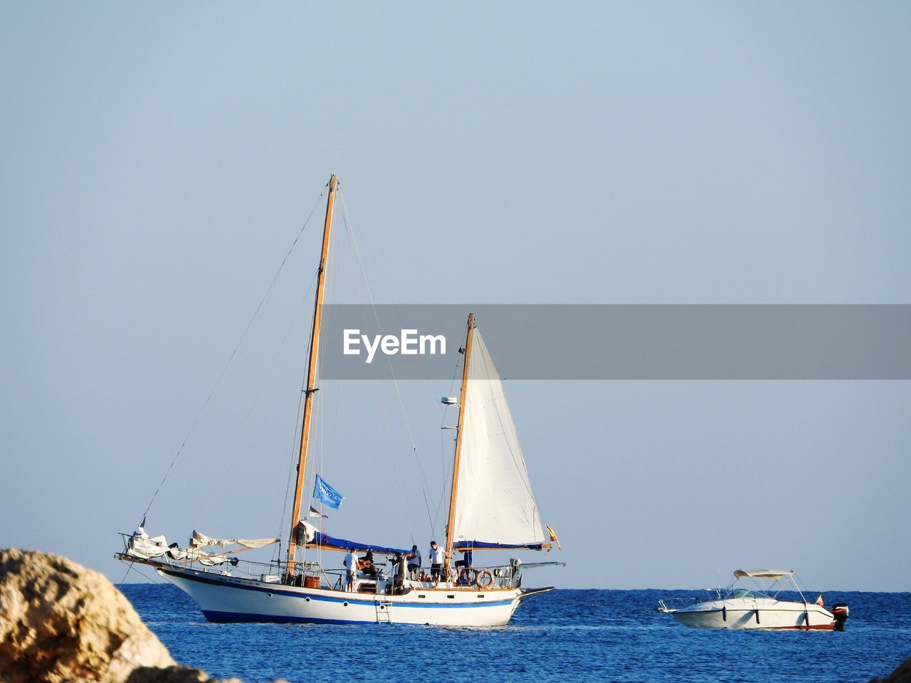 SAILBOAT SAILING IN SEA AGAINST CLEAR SKY