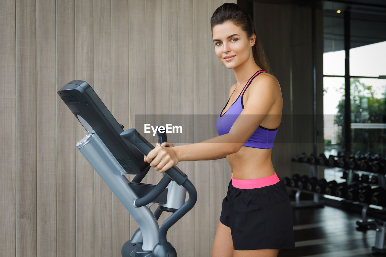 portrait of young woman exercising in gym