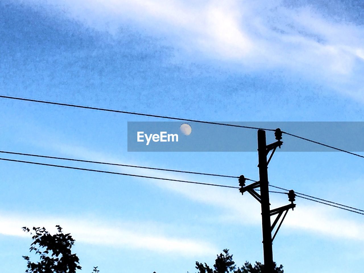 LOW ANGLE VIEW OF POWER LINES AGAINST BLUE SKY