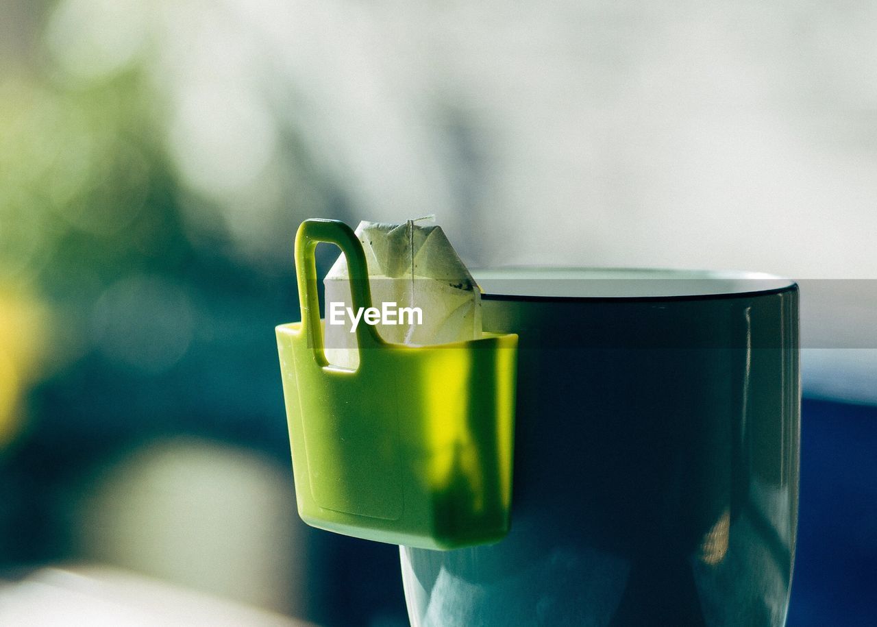 Close-up of green cup with teabag