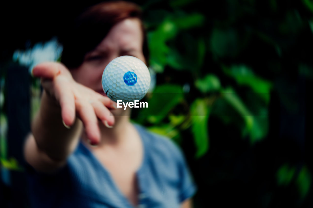 Woman throwing golf ball in back yard