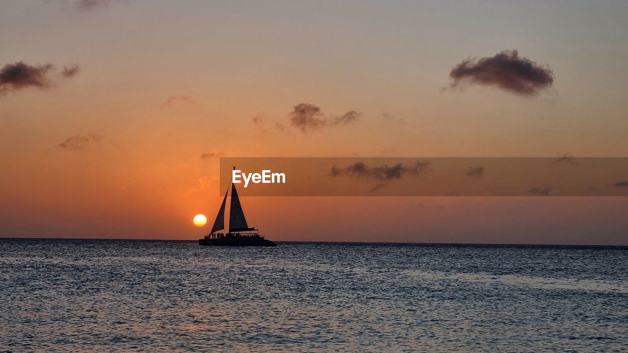 sea, water, sky, sunset, sailboat, nautical vessel, sailing, horizon, transportation, horizon over water, beauty in nature, nature, travel, ocean, mode of transportation, evening, scenics - nature, dusk, vehicle, sailing ship, cloud, holiday, boat, tranquility, vacation, sun, ship, trip, idyllic, tranquil scene, environment, travel destinations, yacht, shore, sunlight, silhouette, beach, dramatic sky, yachting, cruise, urban skyline, motion, seascape, summer, orange color, outdoors, water sports, reflection, sports, luxury, watercraft, tourism, tropical climate, afterglow, coast, land, romantic sky, no people, wave, wind, copy space, adventure, craft, multi colored, journey, moody sky