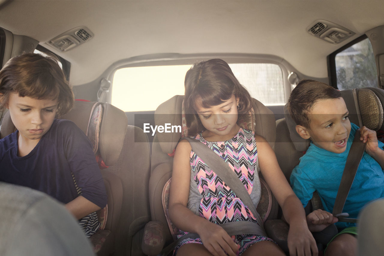 Front view of siblings sitting in car