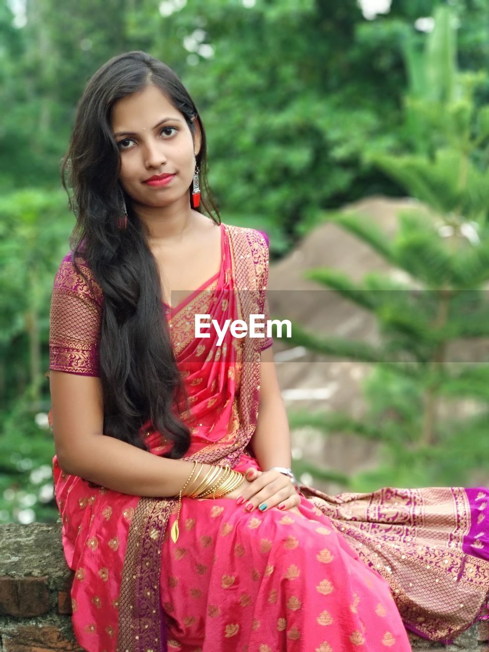 Portrait of beautiful young woman sitting outdoors