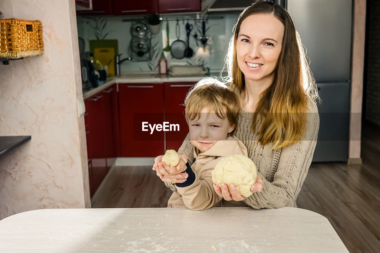 Mother and son preparing food on table