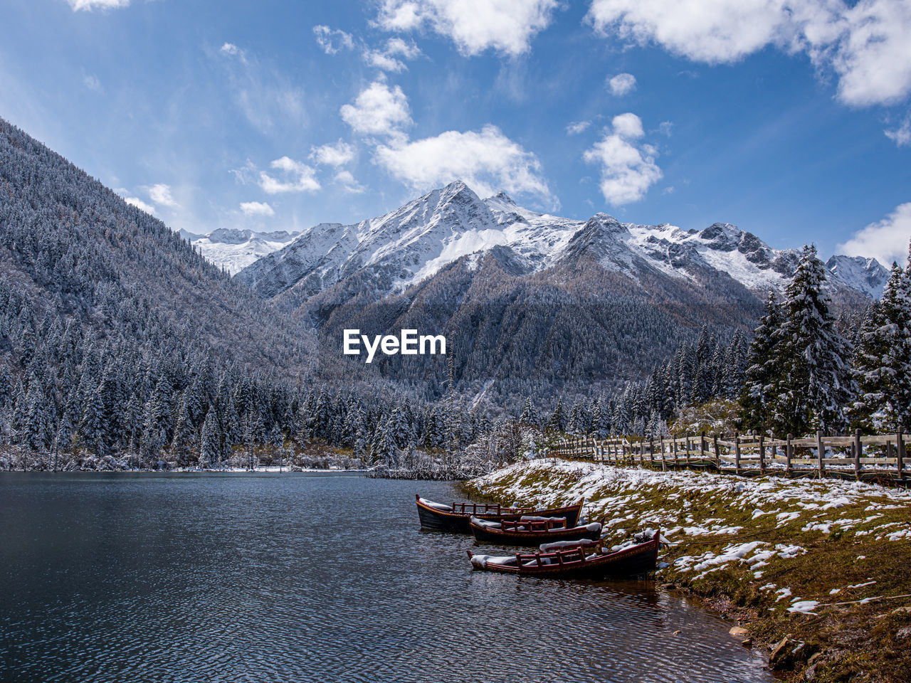Scenic view of lake by mountains against sky