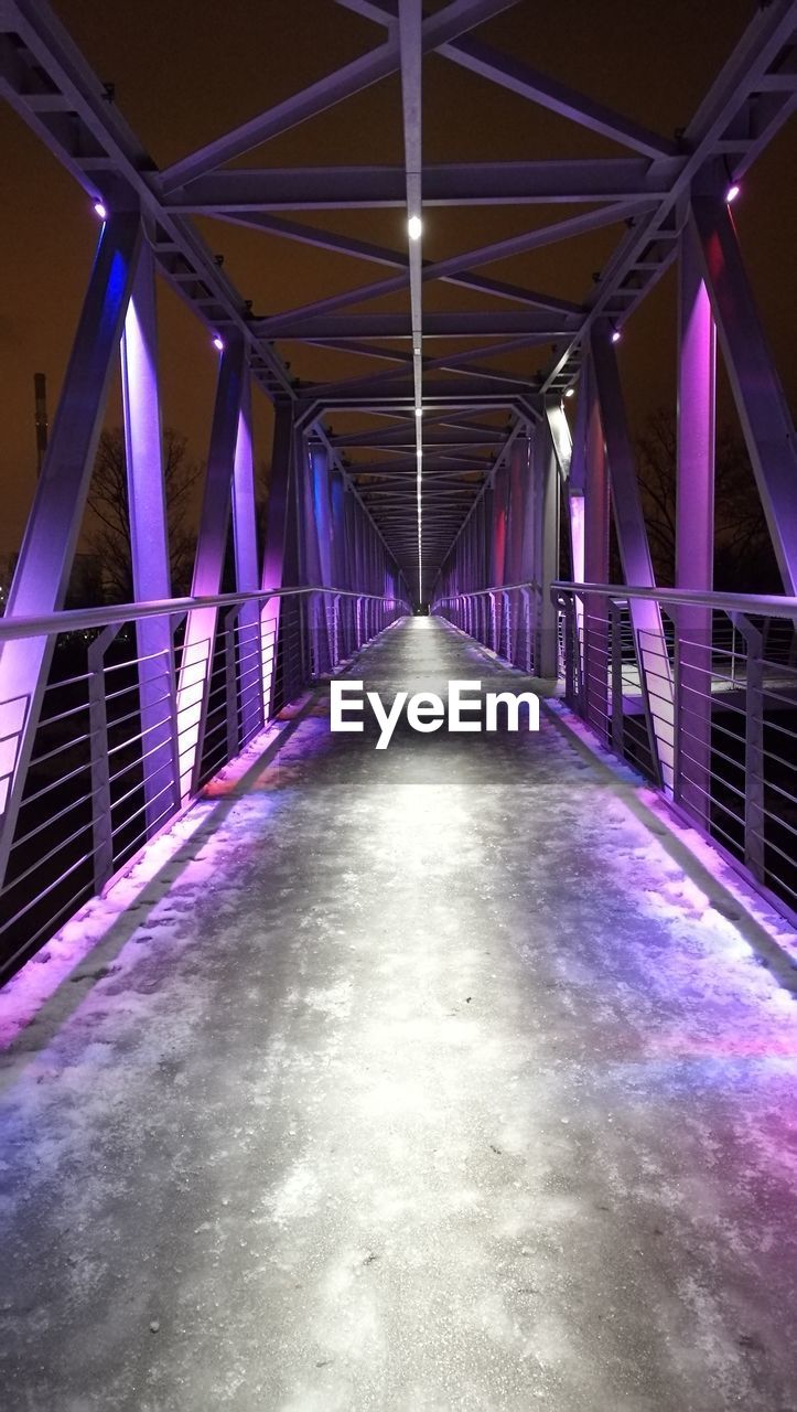 Illuminated covered bridge at night