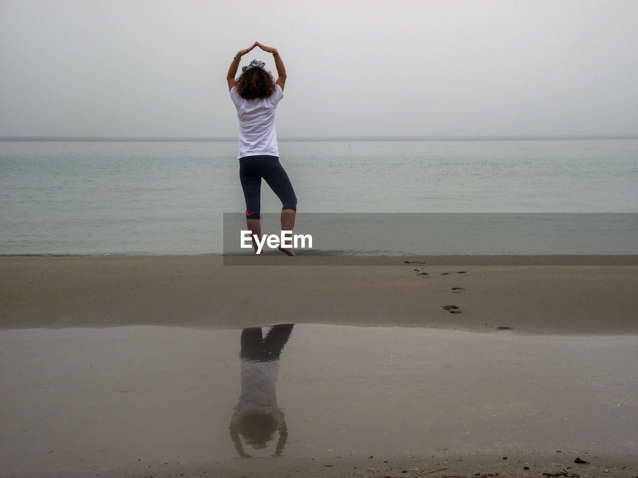 Rear view of woman standing on beach