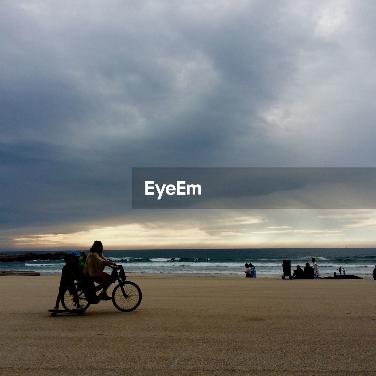 People enjoying at beach during stormy weather