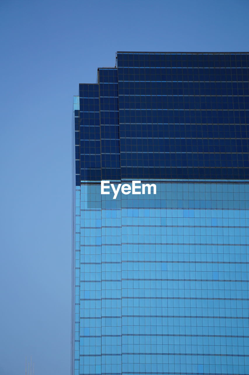 Low angle view of modern building against clear blue sky