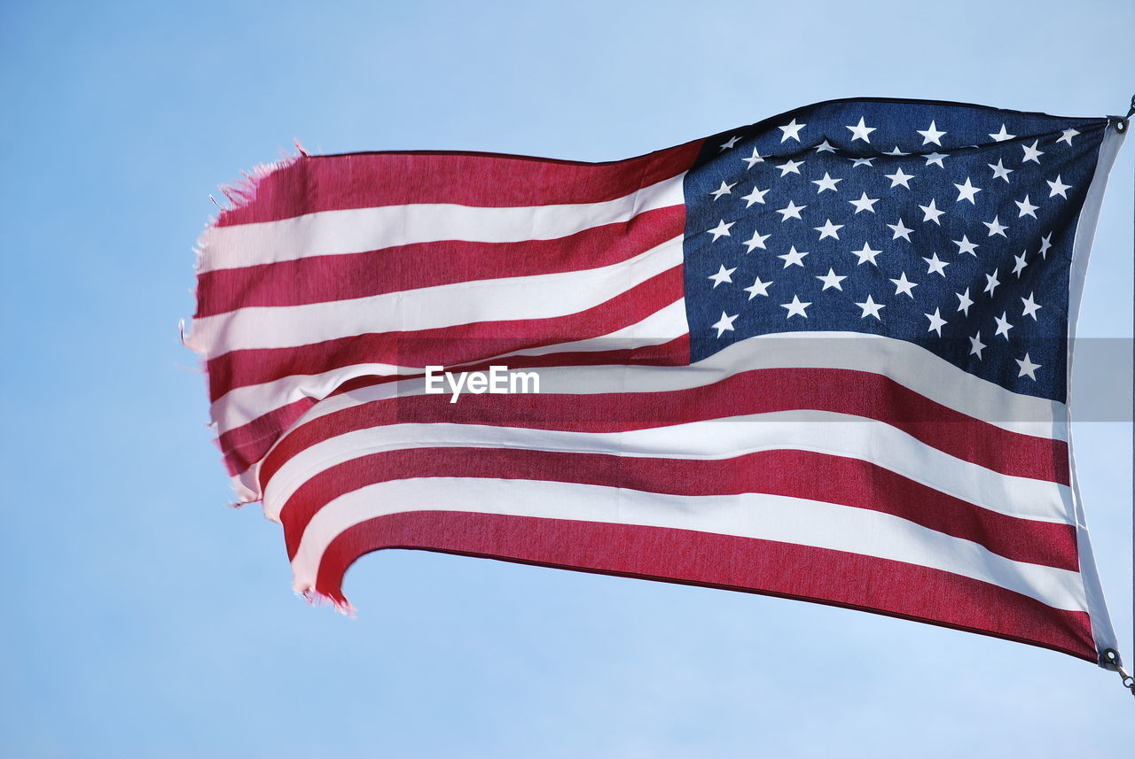 Low angle view of flag against blue sky