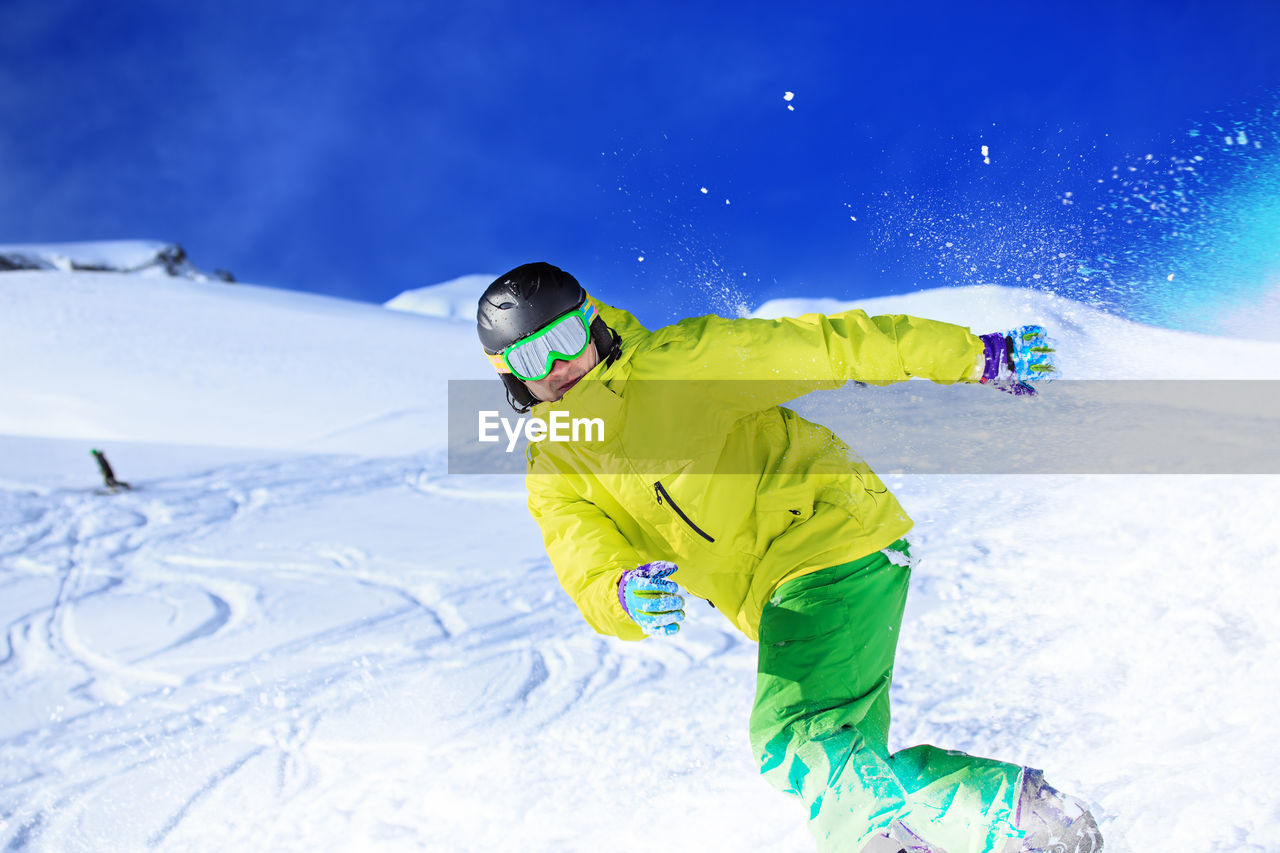 Portrait of young man skiing on snowcapped mountains during winter