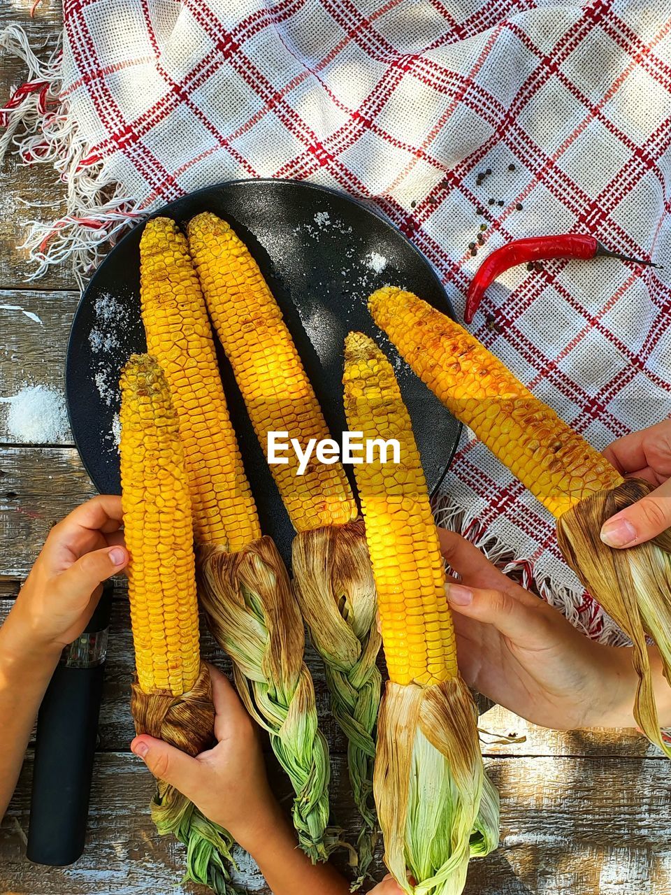 Fresh grilled corn in children's hands