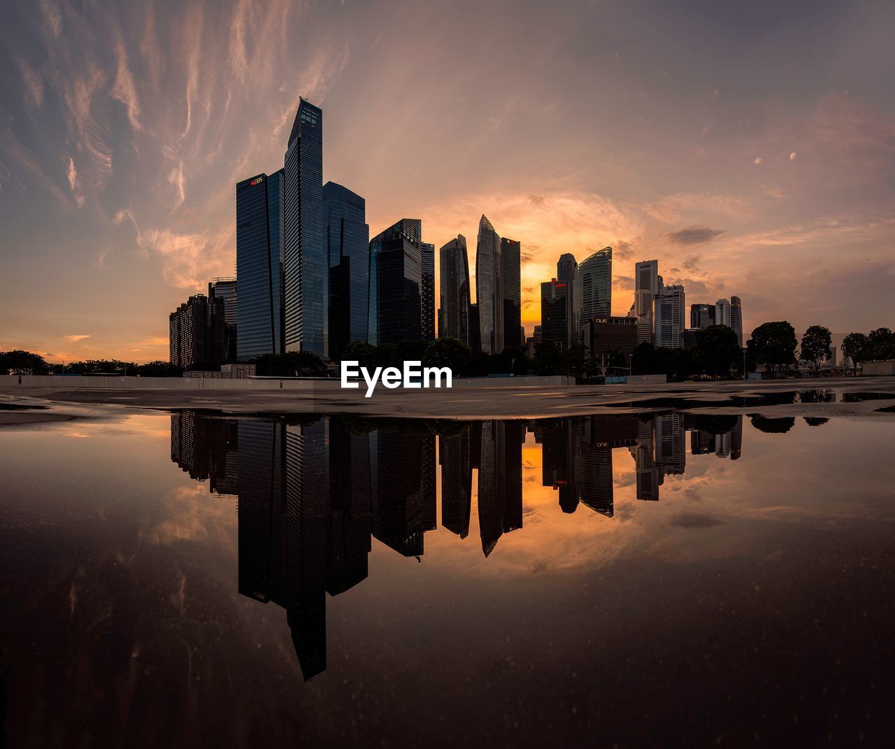 Reflection of buildings in lake against sky during sunset