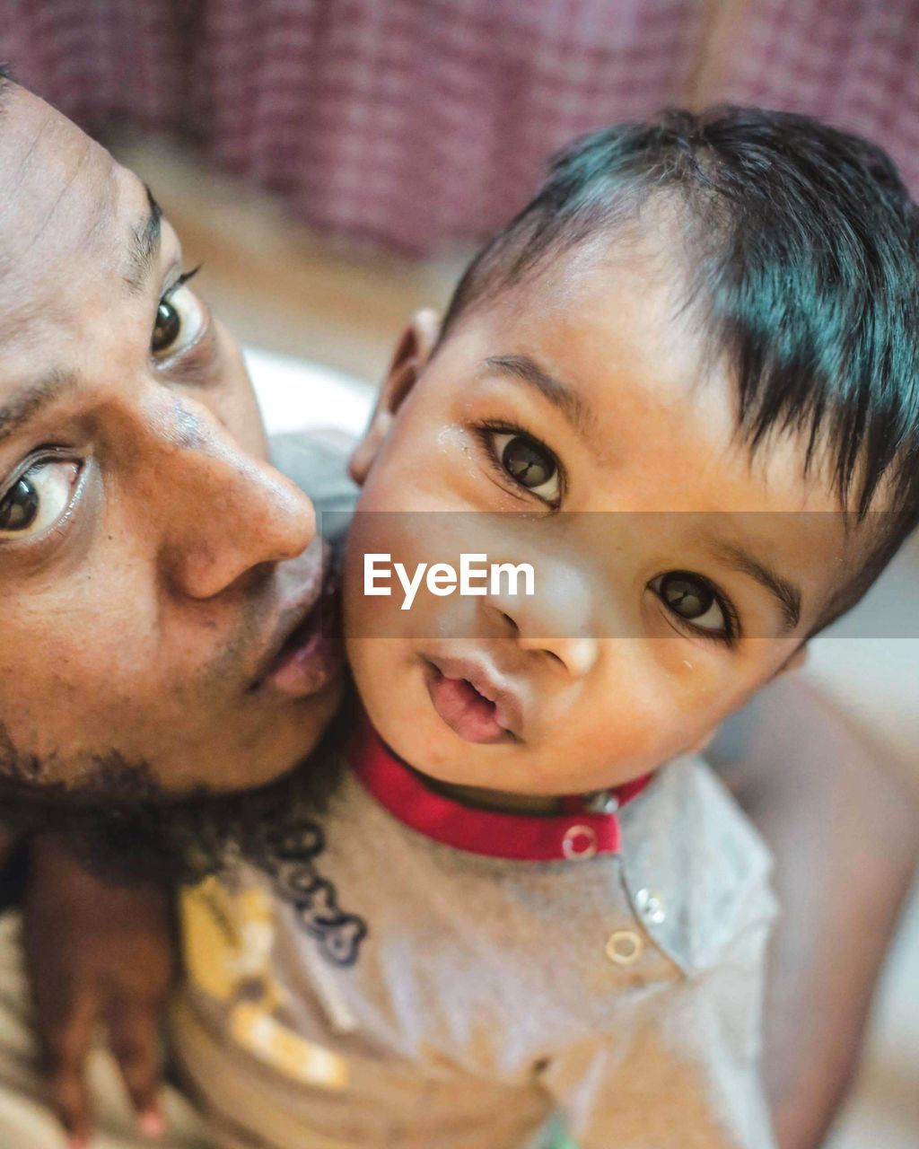 Close-up portrait of father and son at home