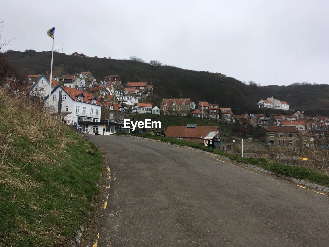 Road amidst buildings in town against sky