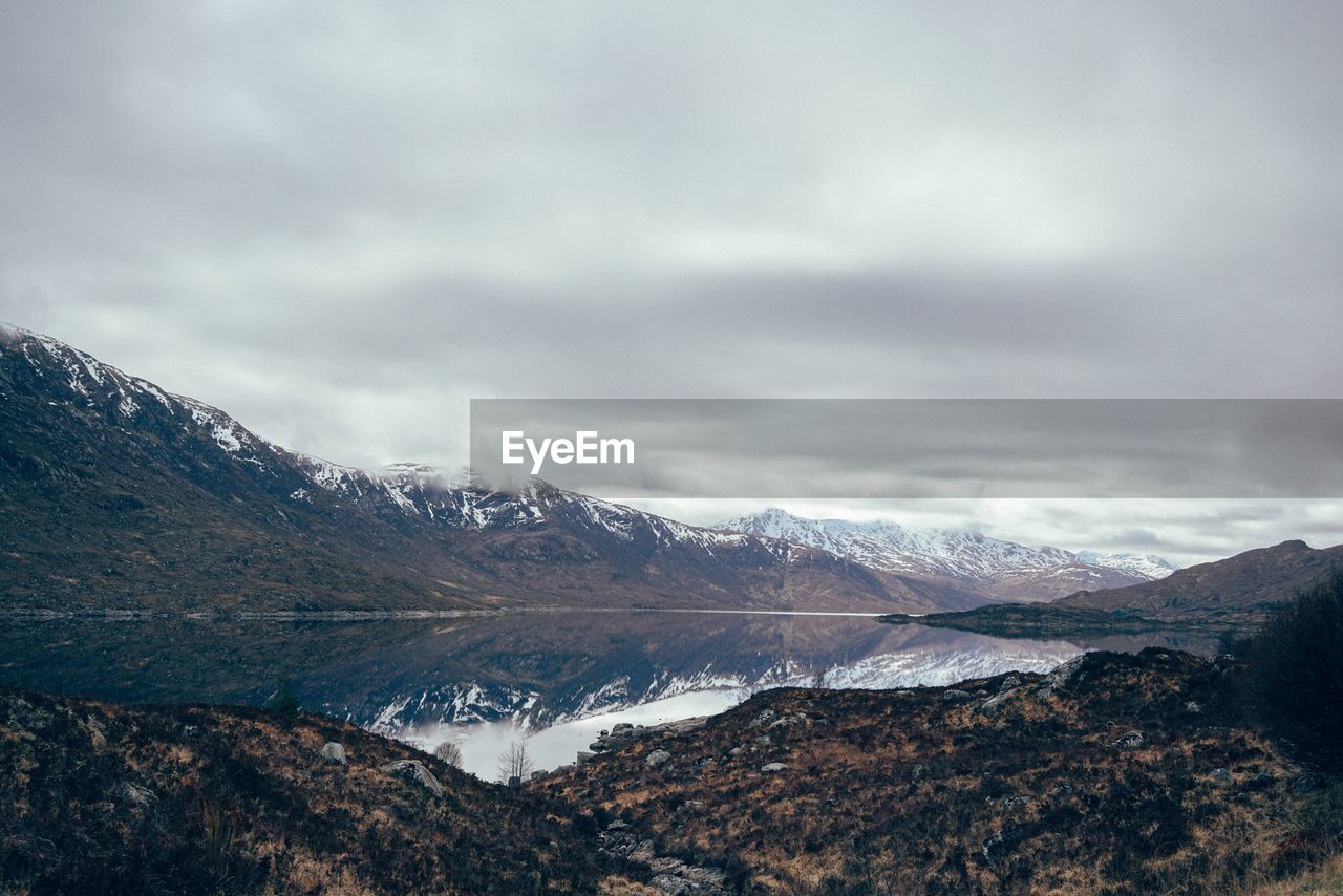 Scenic view of lake against cloudy sky