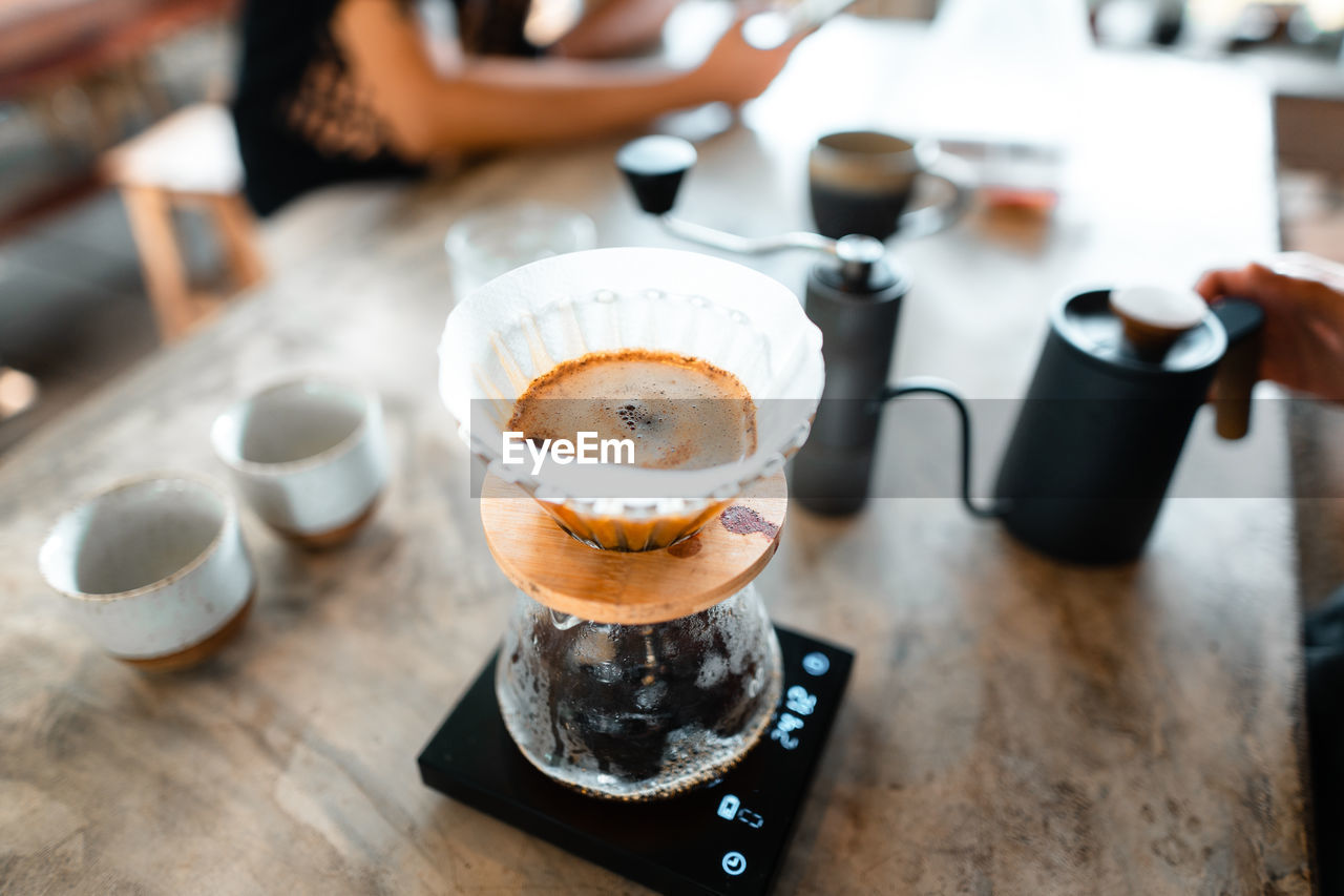 food and drink, coffee, drink, mug, coffee cup, cup, cafe, refreshment, indoors, hot drink, table, food, coffee shop, business, adult, cappuccino, freshness, high angle view, restaurant, meal, focus on foreground, close-up, lifestyles, still life