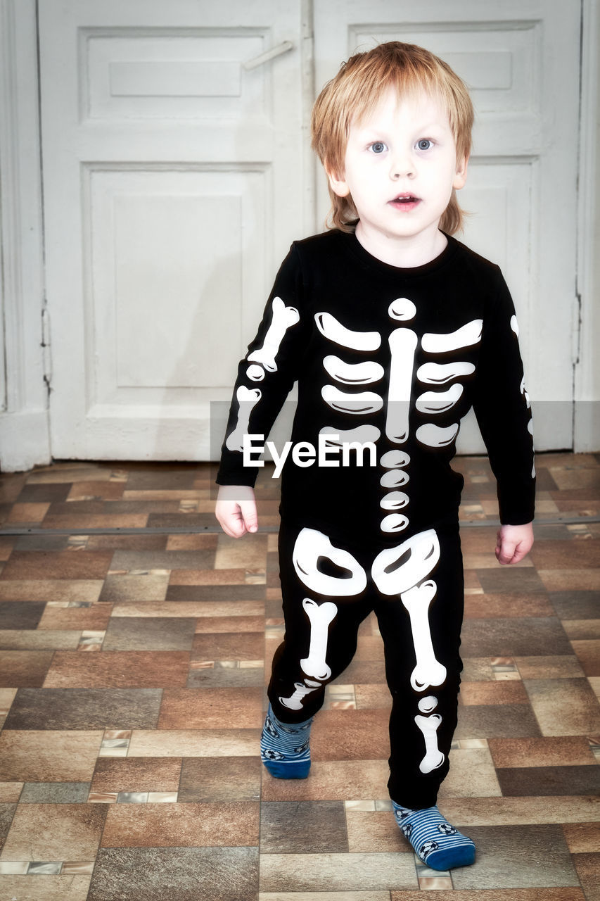 child, childhood, one person, full length, portrait, looking at camera, men, standing, white, black, toddler, striped, blond hair, front view, innocence, cute, clothing, indoors, costume, casual clothing, spring, baby & toddler clothing, emotion, entrance, door, dressing up, person, baby, fun