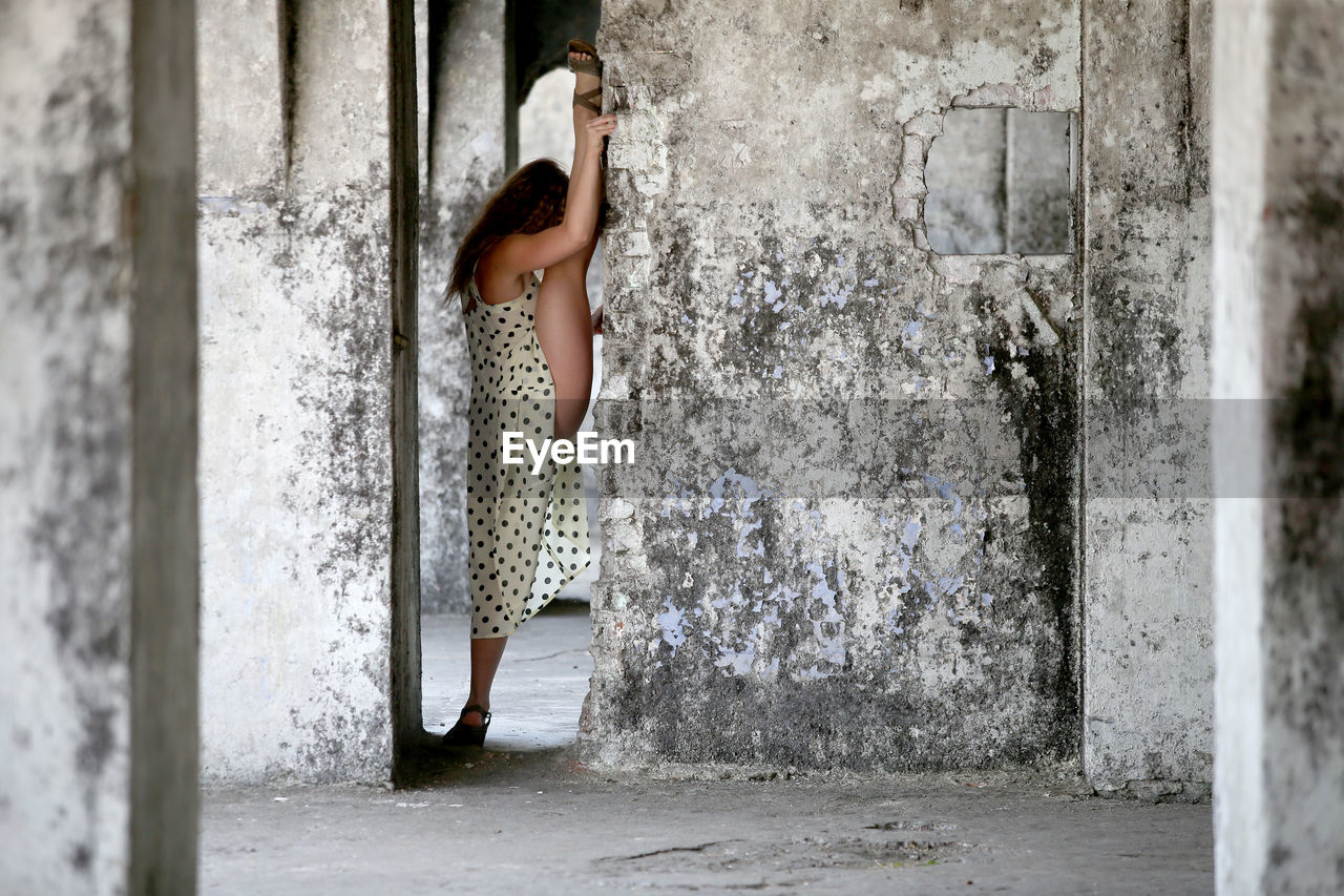 rear view of young woman standing against wall
