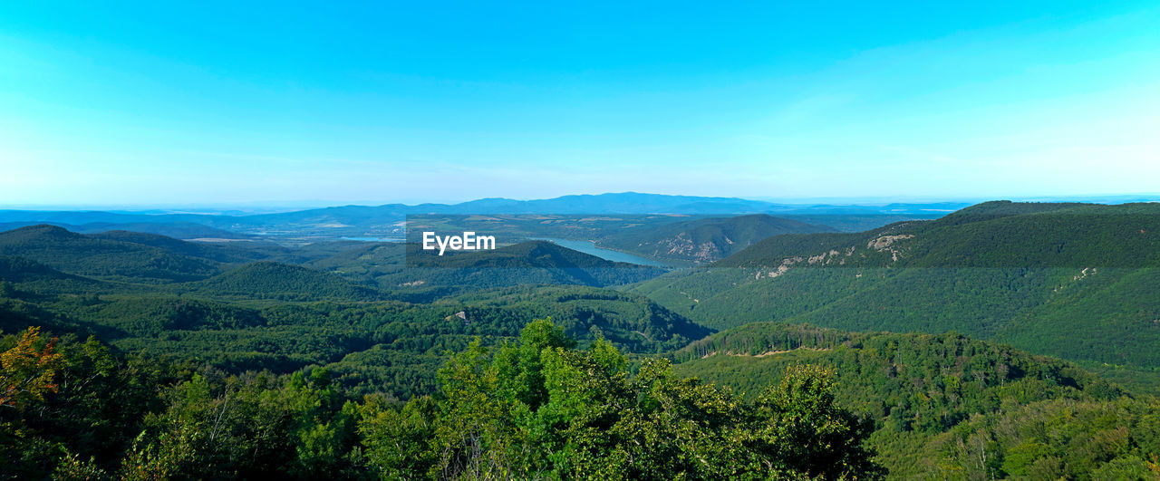 Scenic view of mountains against blue sky