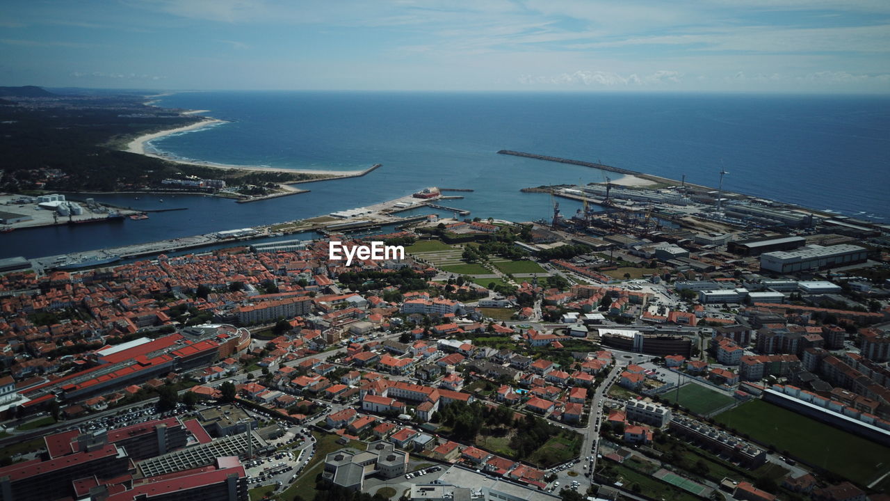 High angle view of buildings by sea against sky