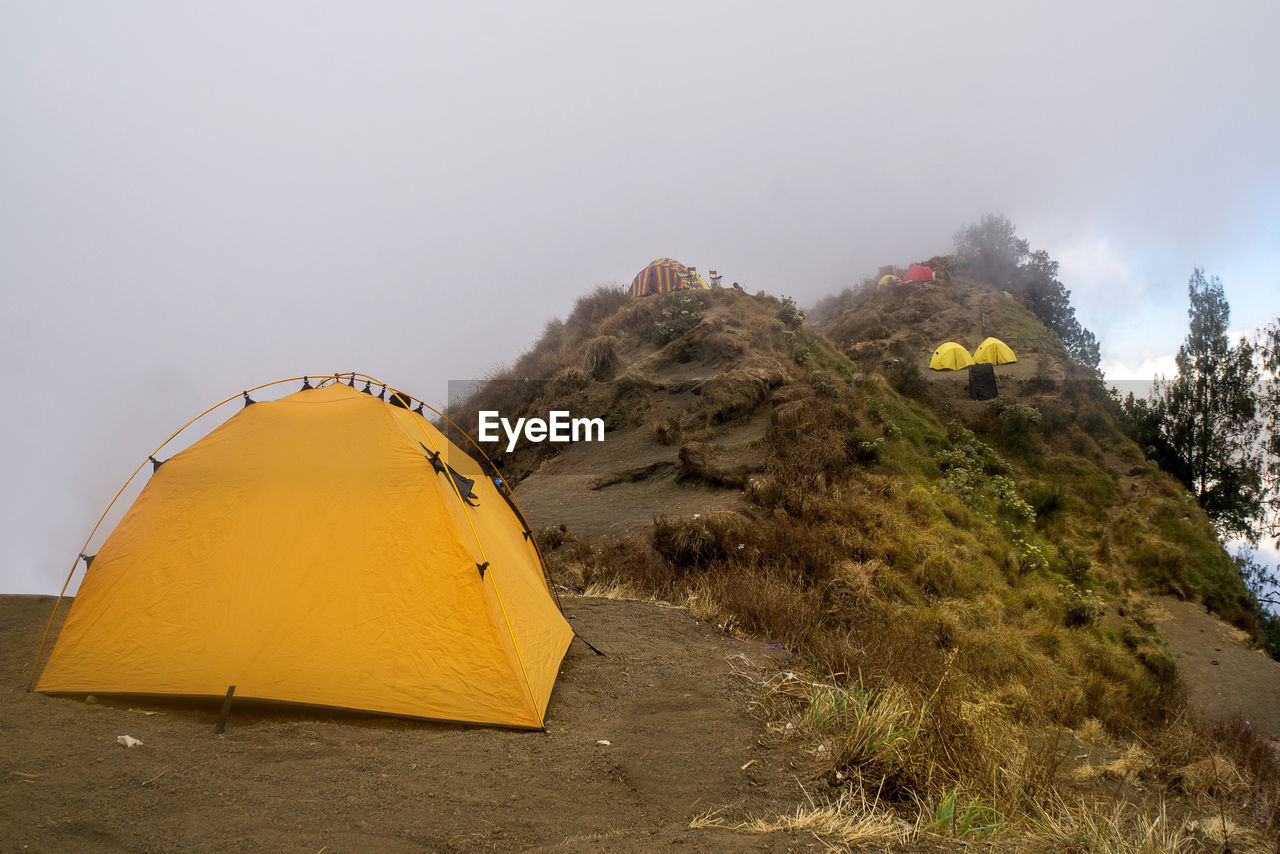 YELLOW TENT AGAINST MOUNTAIN