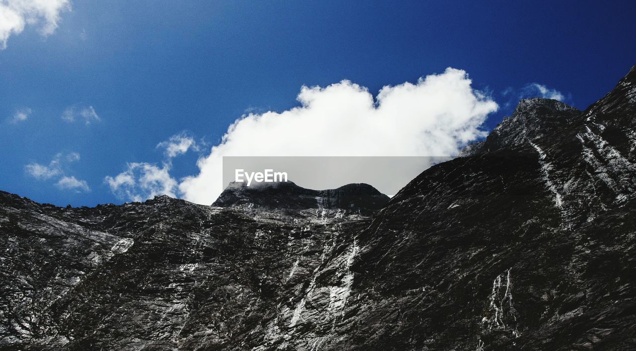 Low angle view of rocky mountain against sky