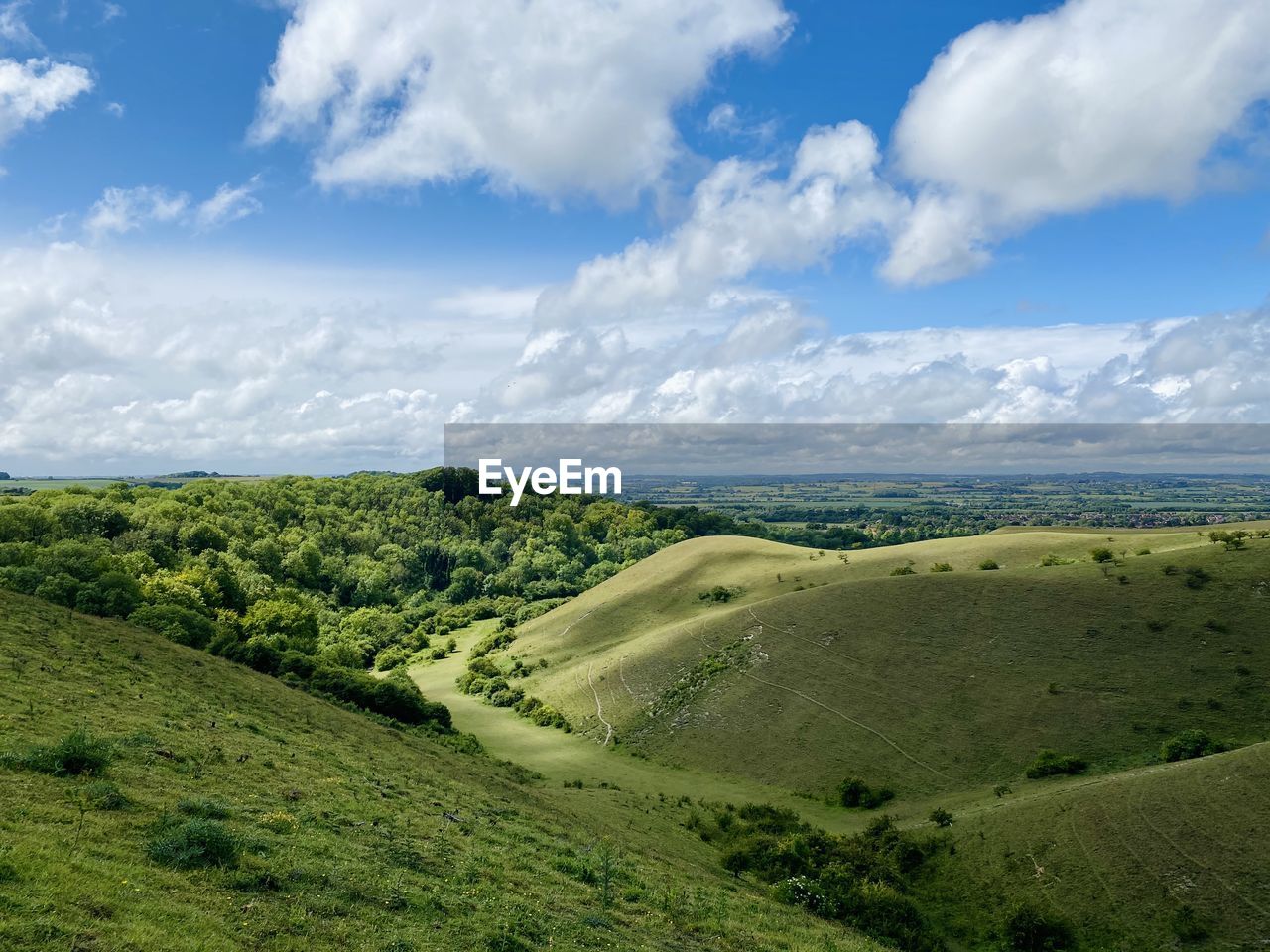 Scenic view of hilly landscape against sky