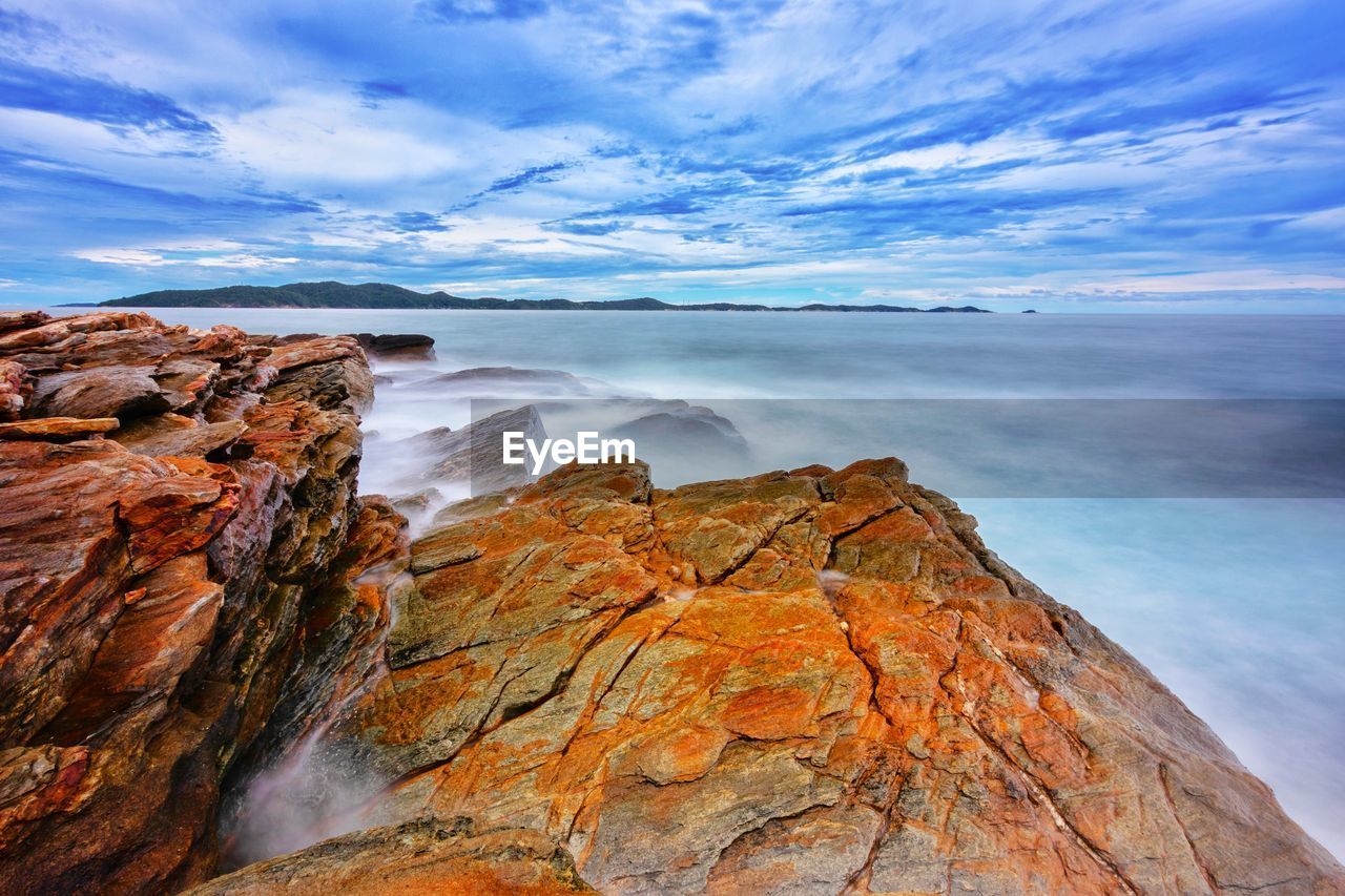 Rock formations in sea against sky