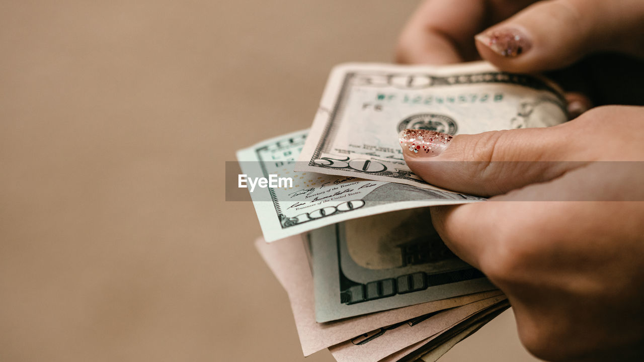 cropped hand of person holding paper currencies