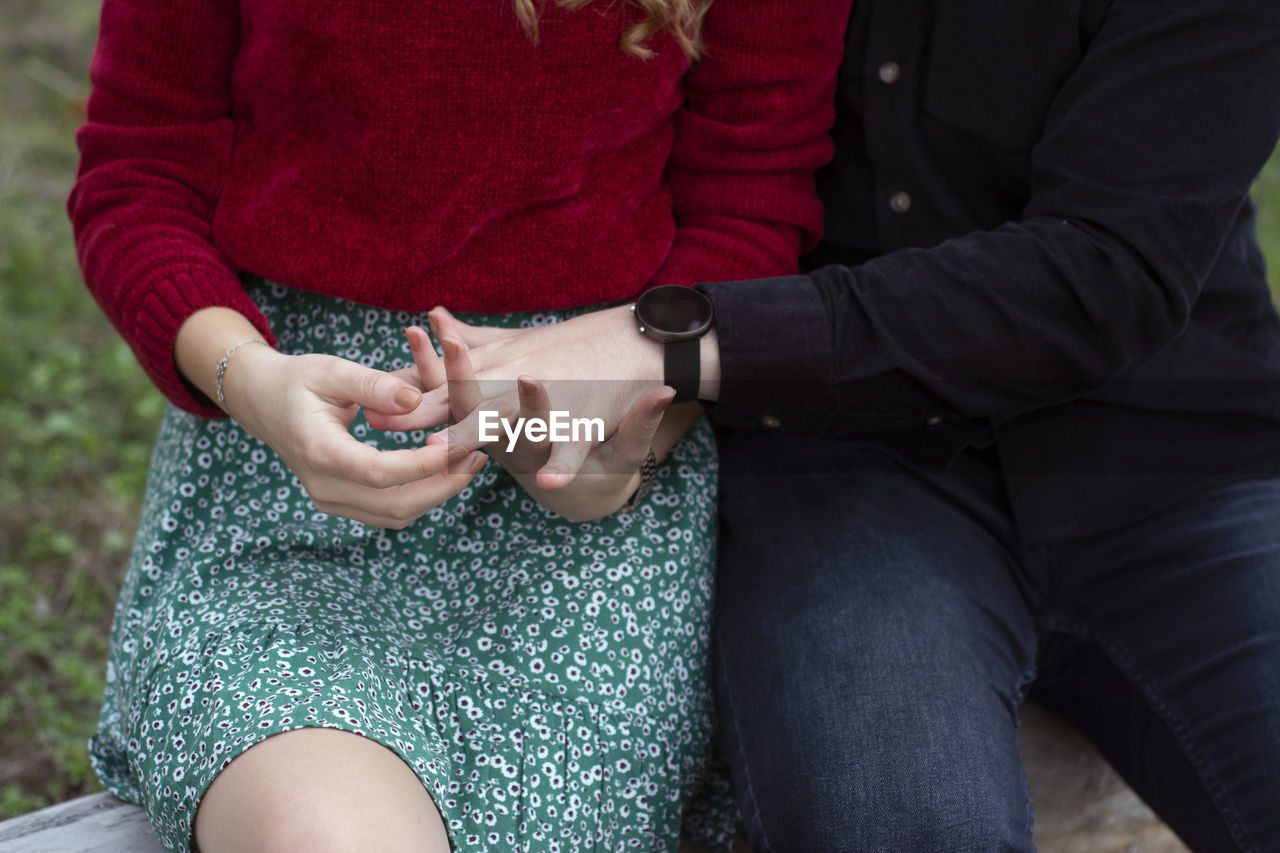 Midsection of couple holding hands