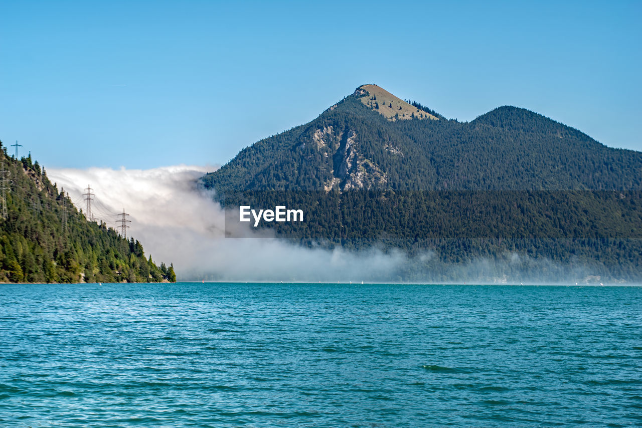 scenic view of sea and mountains against blue sky