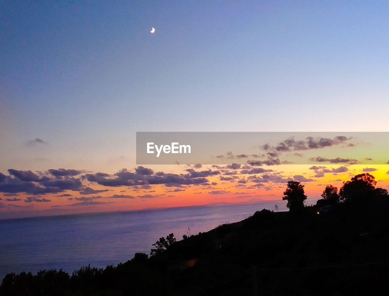 SCENIC VIEW OF SILHOUETTE LANDSCAPE AGAINST ORANGE SKY