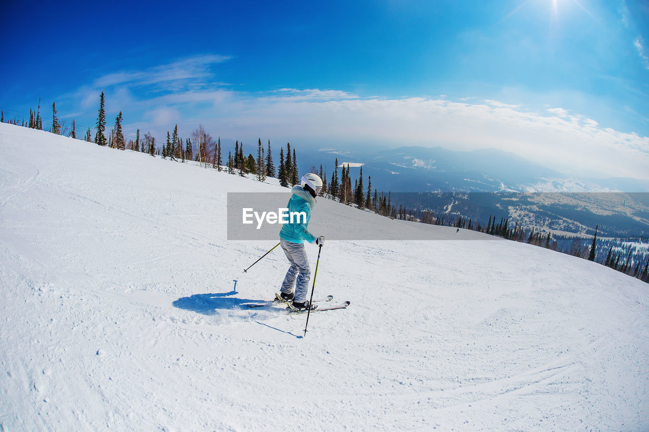 PERSON SKIING ON SNOW COVERED MOUNTAIN