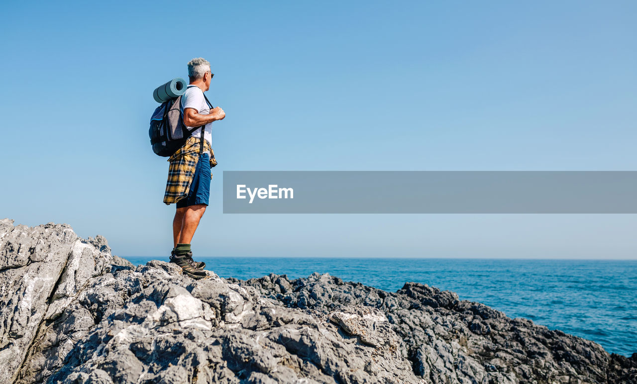 Senior man hiking looking at sea landscape