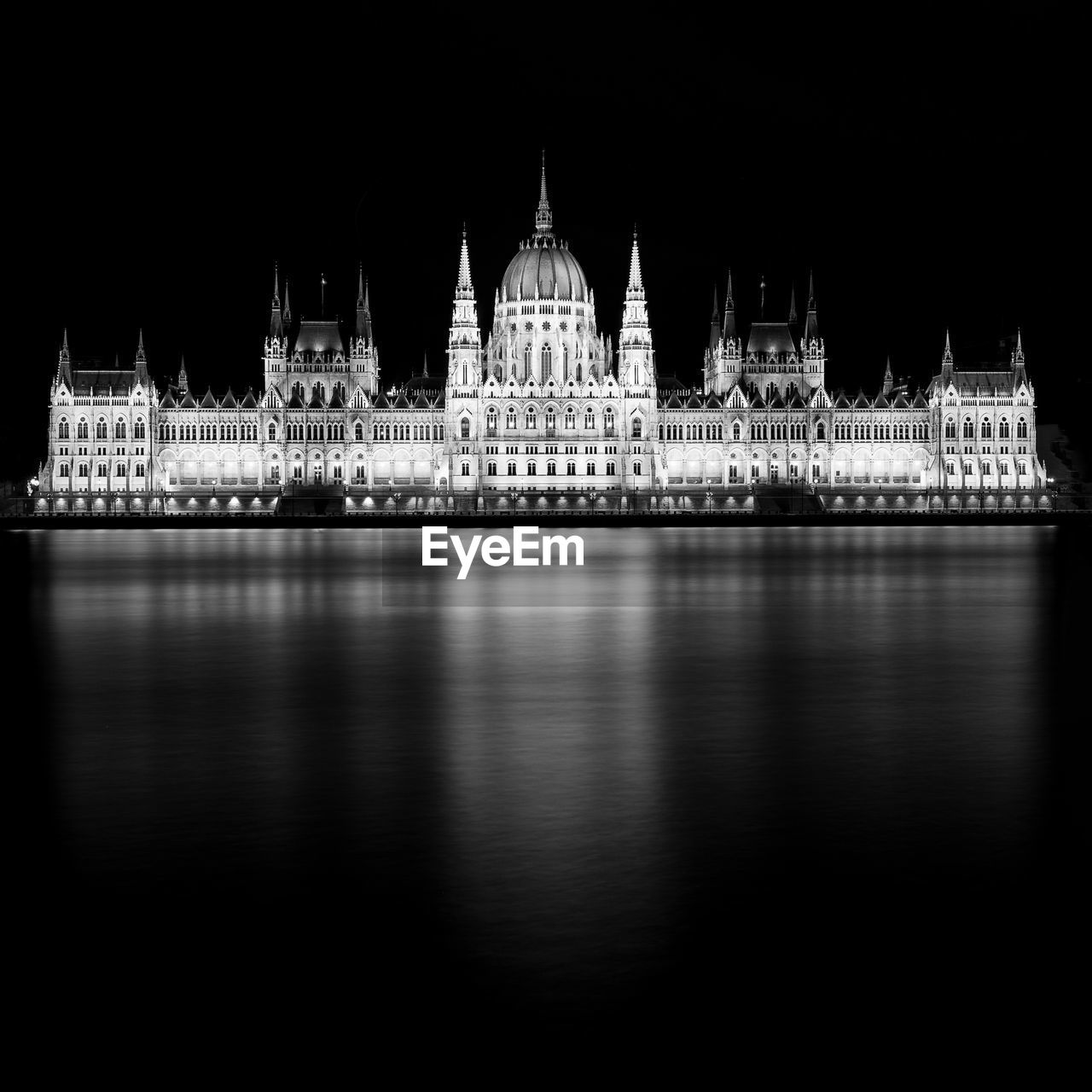 Illuminated cathedral by river at night