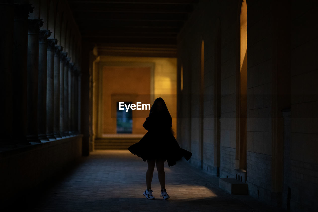 Woman walking in corridor of building