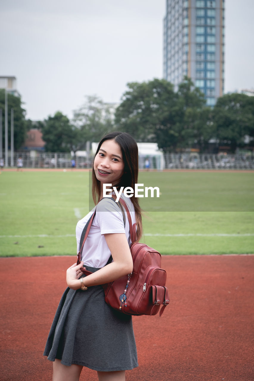 Portrait of smiling young woman standing outdoors