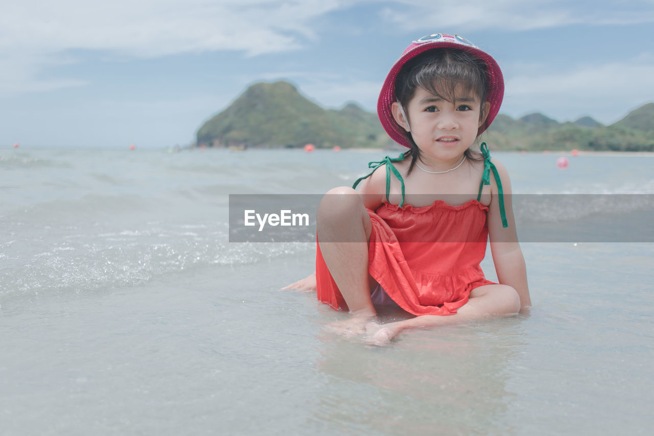 Portrait of cute girl sitting at beach