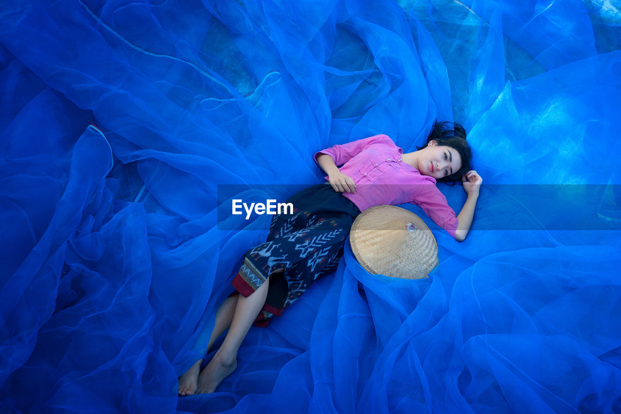 High angle view of young woman lying on net