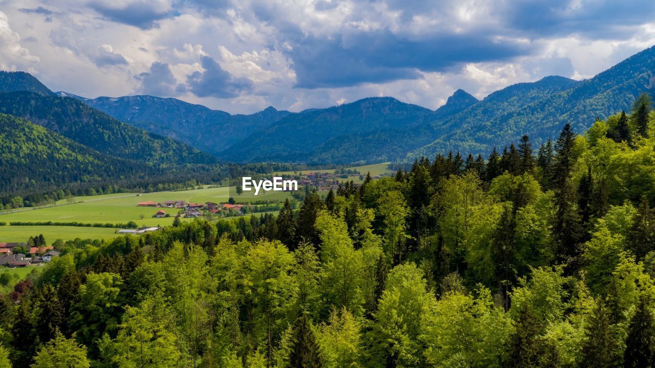 Scenic view of green landscape and mountains against sky