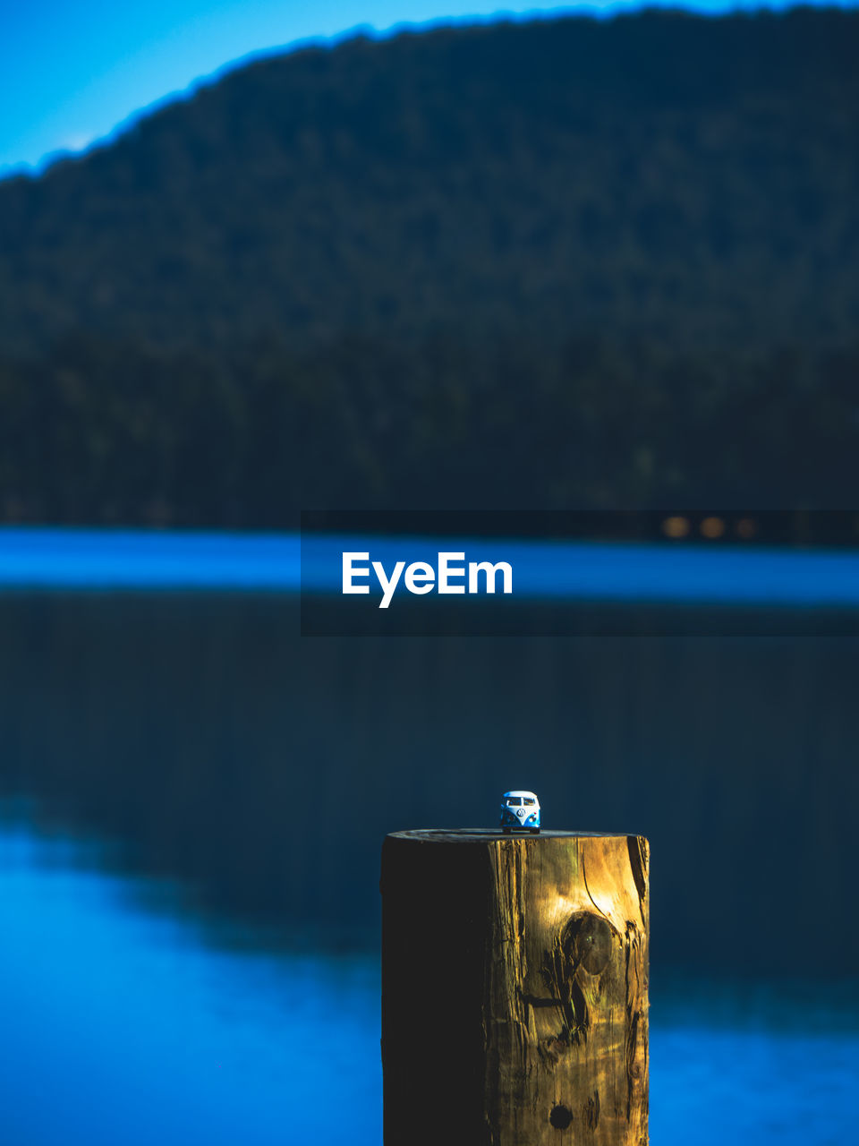 reflection, blue, water, sea, no people, nature, focus on foreground, morning, ocean, wood, horizon, sky, tranquility, mountain, day, scenics - nature, outdoors, tranquil scene, beauty in nature, coast, light, post, sunlight, cloud