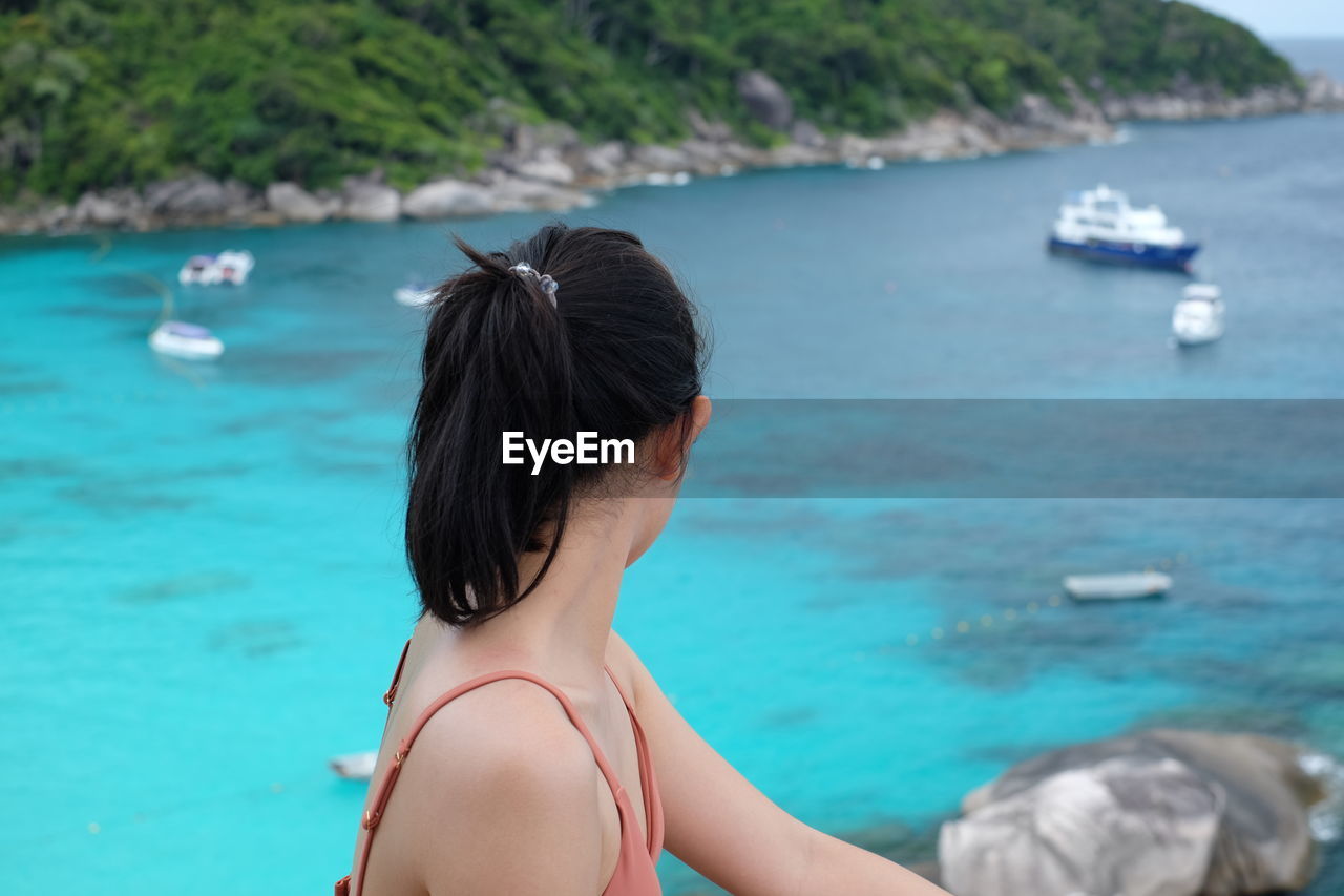 Side view of woman looking at sea