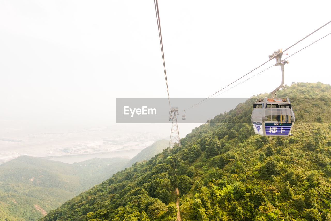 OVERHEAD CABLE CAR AGAINST MOUNTAINS