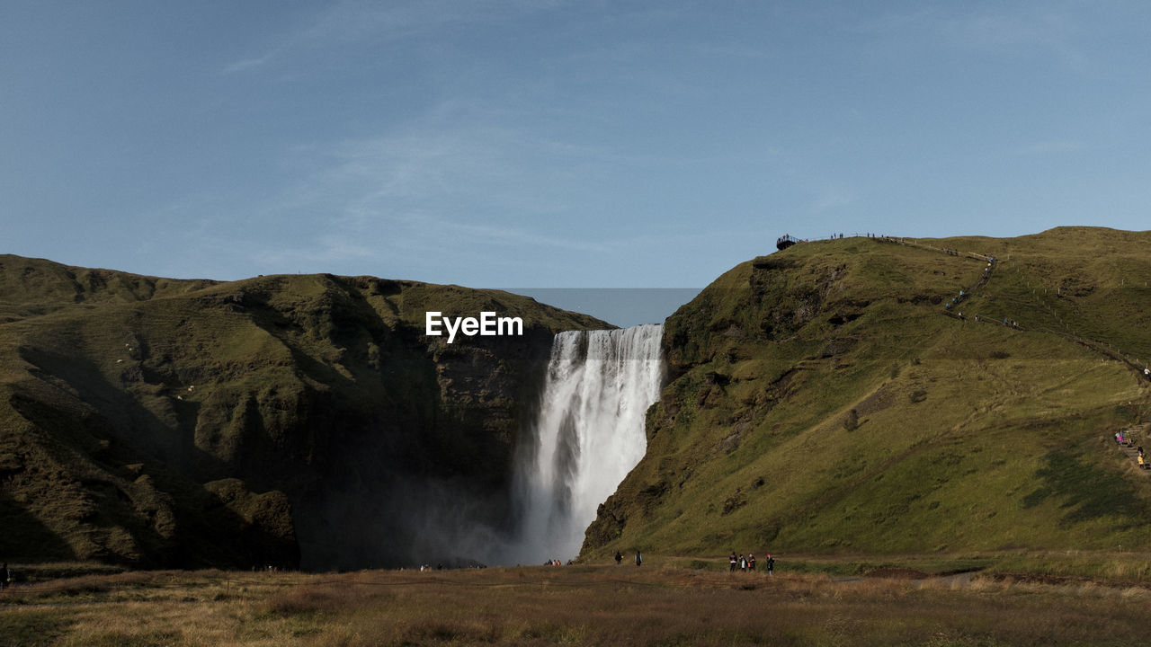 Scenic view of waterfall against sky